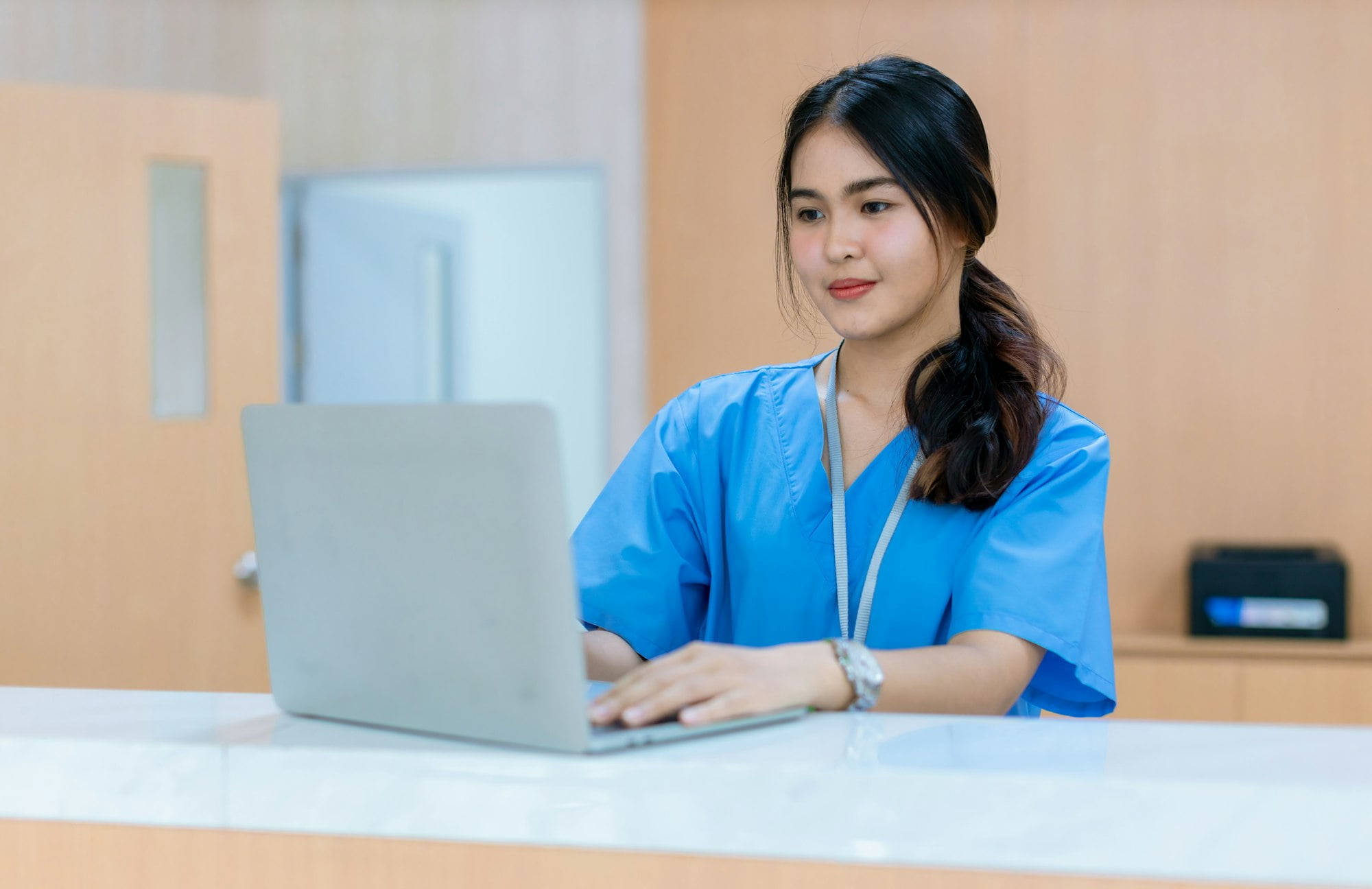 Woman Healthcare worker using laptop in hospital.